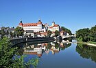 Schloss Neuburg an der Donau Stadtansicht mit Schloss und Brücke, Spiegelung im Fluss, blauer Himmel, Bäume am Ufer